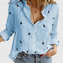 Light blue Isabella relaxed V-neck blouse with button front from Lumina Wear, shown on a model in a casual setting.