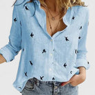 Light blue Isabella Lumina Wear relaxed V-neck blouse with button front, displayed on a hanger.