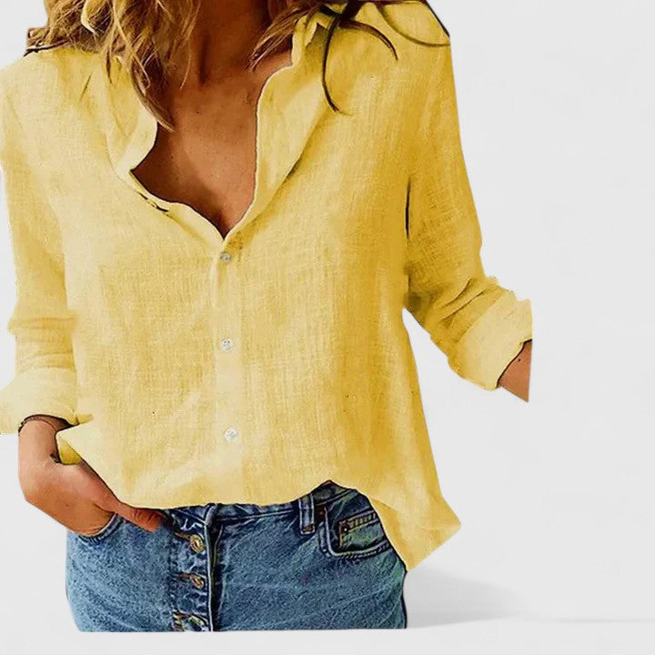Isabella Lumina relaxed V-neck blouse with button front, lightweight fabric, in soft neutral color, displayed on a hanger.