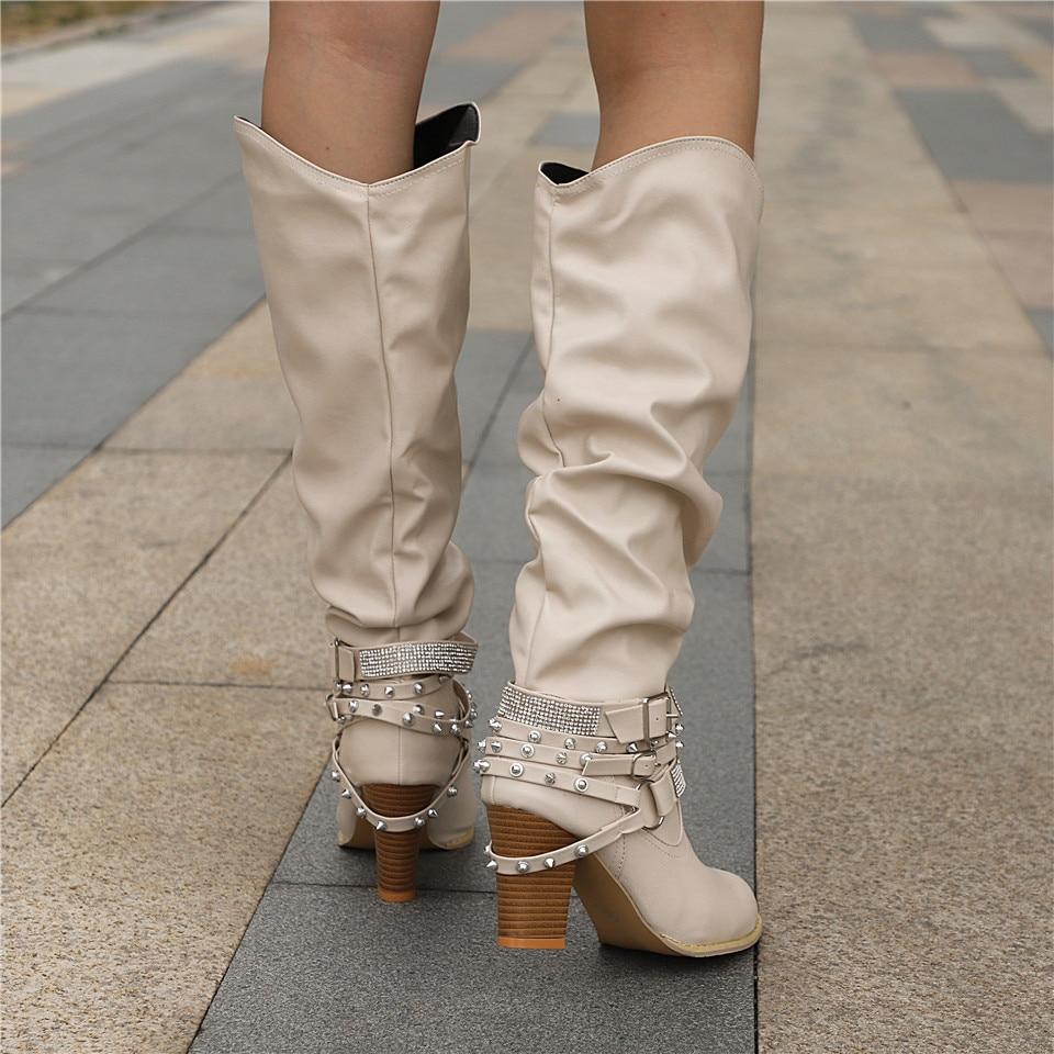 Women’s knee-high boots with studded straps, slouch design, and block heel from Lumina Wear’s Isabella collection.