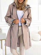 Women's waterproof Isabella parka by Lumina Wear with checked lining and drawstring waist, tailored outerwear for rainy days.