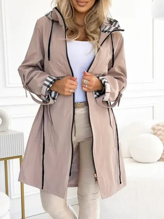Women's waterproof Isabella parka by Lumina Wear with checked lining and drawstring waist, tailored outerwear for rainy days.