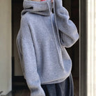 Lumina Wear Milan oversized merino wool hoodie with adjustable neck, relaxed fit, breathable fabric, shown in a cozy, casual style.