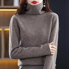 Lumina Wear Sofia cozy loose-fit sweater with stacked collar, soft knit fabric, worn by a woman in a casual indoor setting.