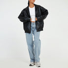 Lumina Wear Sofia oversized faux leather bomber jacket with relaxed fit, shown in a stylish, casual outdoor setting.
