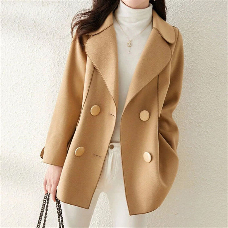 Elegant double-breasted wool coat with structured lapels from Lumina Wear, styled on a woman, in a neutral color.