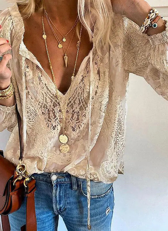 Victoria Lumina bohemian V-neck blouse with decorative detailing, featuring flowing fabric and intricate embellishments.