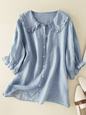 Lumina Wear Victoria relaxed fit ruffle collar summer top displayed on a hanger, showcasing its lightweight fabric and feminine design.