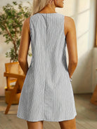 Blue Allison™ sleeveless striped dress by Lumina Vancouver, showcased on a hanger with a modern design and vibrant pattern.