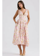 Yellow floral Angelica elegant summer dress by Lumina Vancouver, shown with a flowing fabric and sleeveless design.