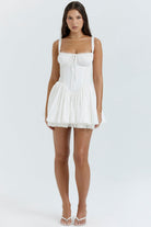 White mini dress by Lumina Vancouver with lace trim on the bodice and a fitted silhouette.