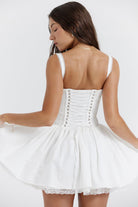 White mini dress with lace-trim bodice by Lumina Vancouver, featuring a fitted silhouette and delicate lace details.