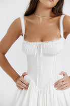 White mini dress by Lumina Vancouver with lace-trim bodice and short sleeves, displayed on a hanger.