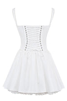 White mini dress by Lumina Vancouver with lace trim bodice, showcased on a hanger with a focus on the detailed lace design.