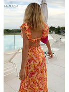 Orange Ariella floral ruffle dress by Lumina Vancouver, perfect for holiday vibes, shown on a small-sized child.