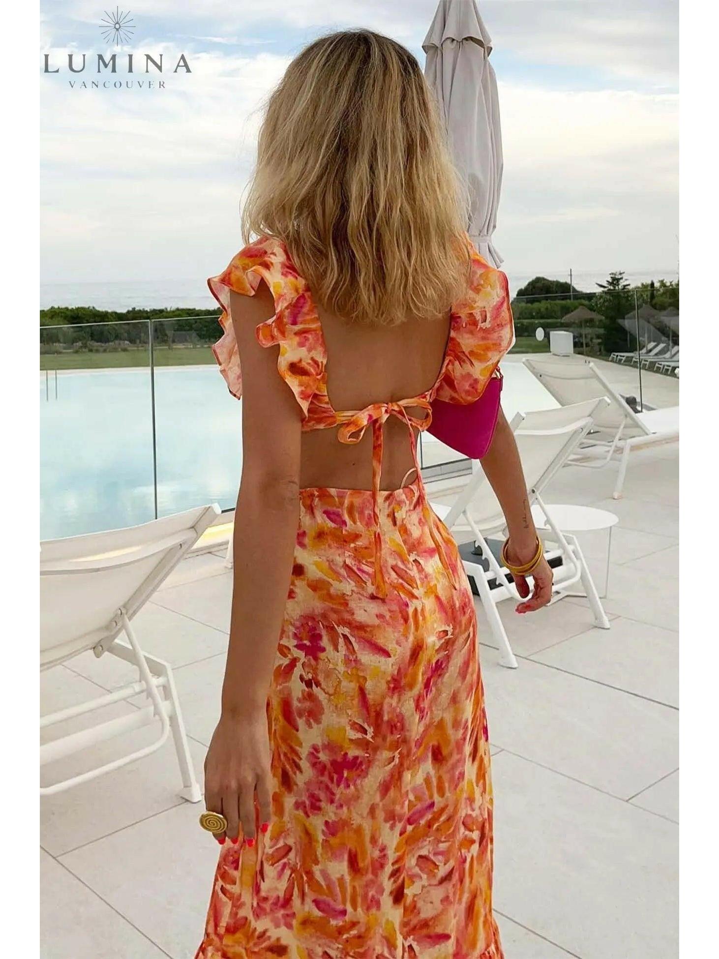 Orange Ariella floral ruffle dress by Lumina Vancouver, perfect for holiday vibes, shown on a small-sized child.