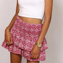 A vibrant pink bohemian ruffle skirt from Lumina Wear, featuring playful print and flowing style, perfect for casual and summer looks.