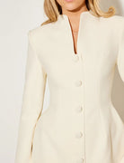 Lumina Vancouver Aurora coat dress with a statement bow collar in white, showing the elegant design and tailored fit.