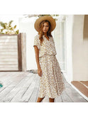 A white printed summer dress by Lumina Wear featuring a flowing design, perfect for warm weather, displayed on a hanger.
