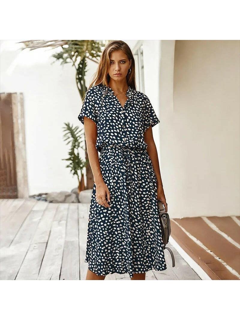 A white Ayesha™ printed summer dress by Lumina Vancouver displayed on a hanger, showcasing its lightweight fabric and floral pattern.