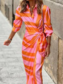 Orange and pink Belle Sunshine Dress by Lumina Wear, sleeveless, perfect for wedding guests, shown on a model.