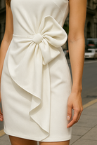 White Camille Lumina Wear mini dress with bow detail, sleeveless design, perfect for casual or semi-formal occasions.