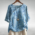 Charlotte Breezy Leaf Print Blouse by Lumina Wear, featuring a button-up design and vibrant leaf pattern in blue.
