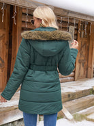 Green Charlotte quilted puffer jacket with faux-fur hood by Lumina Wear, shown on a model with a stylish winter look.