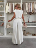 Black Daisy Lumina Wear elegant pleated two-piece clothing set with flattering fit, displayed on a hanger.