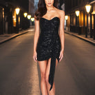 Black off-shoulder sequin mini dress by Lumina Vancouver featuring a fitted silhouette and shimmering embellishments.
