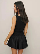 Black sleeveless A-line mini dress by Lumina Vancouver, showcasing a fitted bodice and flared skirt, perfect for casual and semi-formal wear.