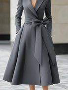 Grey Yvette A-line coat dress by Lumina Vancouver with bow belt detail, shown on a model in a stylish outdoor setting.