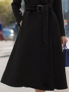 Black Lumina Vancouver Edith wool-blend midi coat with belted lapel collar, shown on a model in a close-up view.