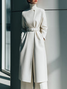 White Renee Lumina Vancouver belted minimalist wool coat with clean lines and tailored fit, shown on a model.