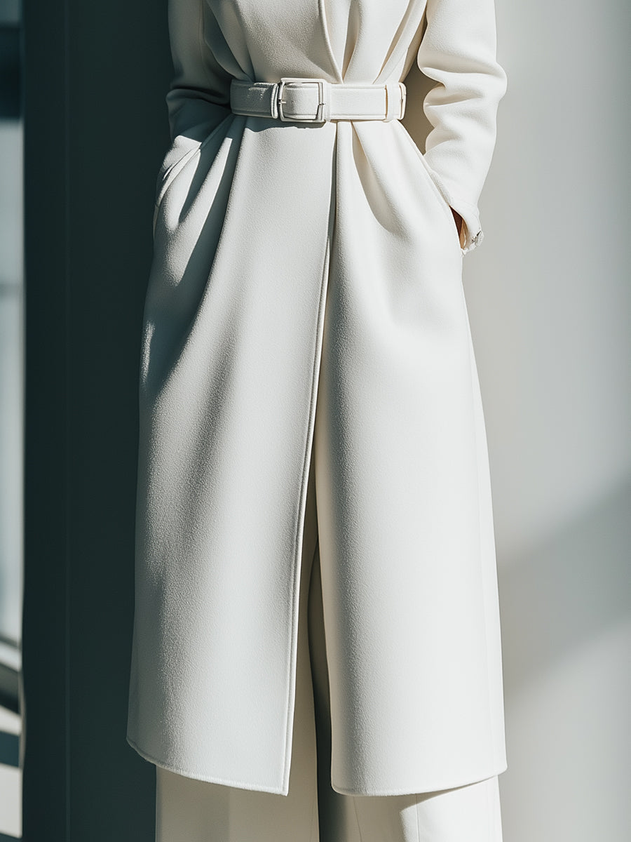 White belted minimalist wool coat by Lumina Vancouver, showing the tailored design and belt detail on a model.