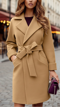 Beige Elena Lumina Wear belted wrap coat with structured design, shown on a model, ideal for stylish winter or fall outfits.