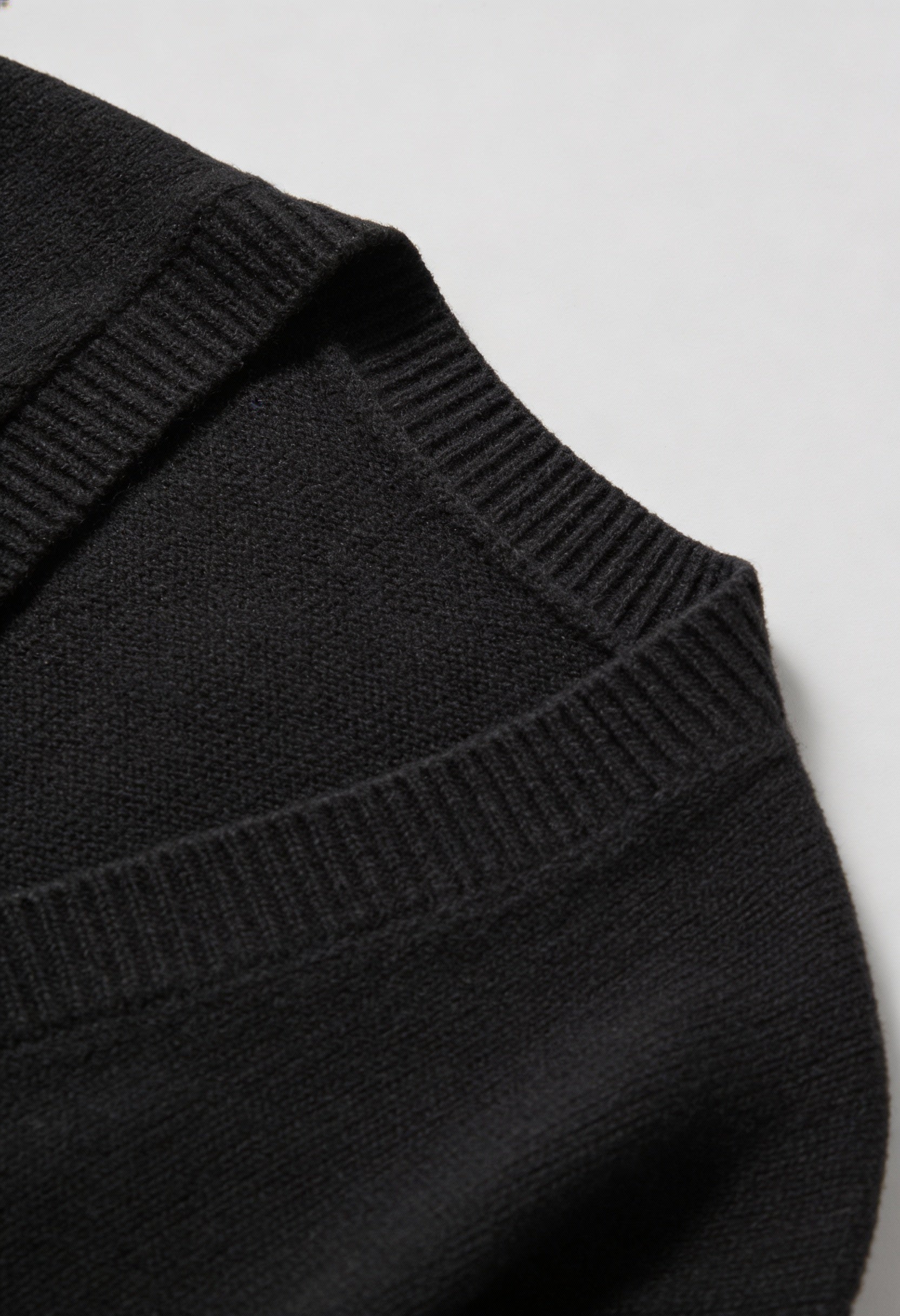 Black knit cardigan with ribbed details from Lumina Wear, featuring a cozy fit and classic style for casual wear.