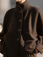 Chocolate stand-collar jacket by Lumina Vancouver featuring a sleek design, worn by Elena in a close-up shot.