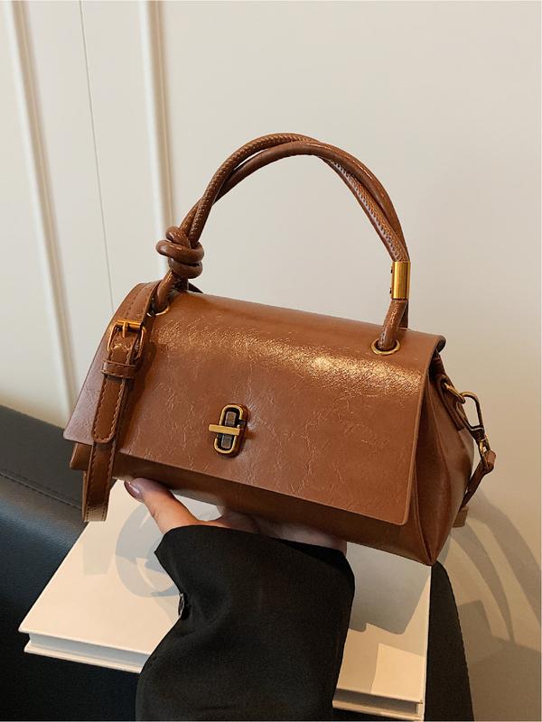 Black Lumina Wear Emma chic versatile satchel handbag with crossbody strap, featuring a sleek design and multiple carrying options.