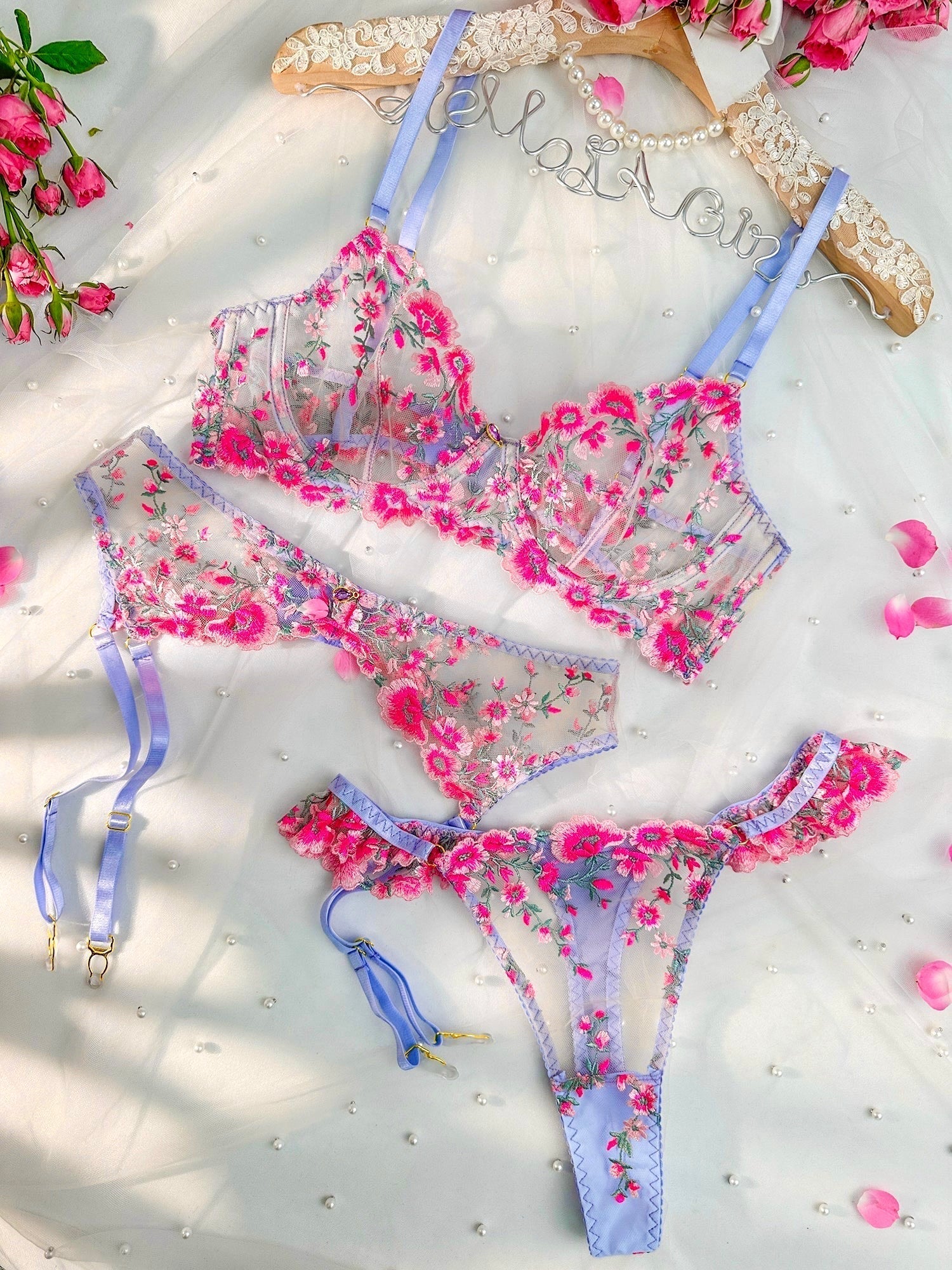 Lumina Wear pink lingerie set with floral embroidery, including bra, panties, and garter belt in a delicate, feminine design.