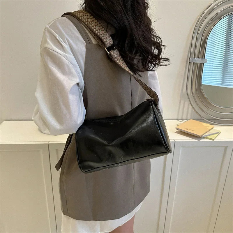 Lumina Wear Florence minimalist black crossbody bag with patterned strap, measuring 9.45in long and 5.91in high.