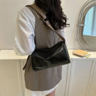 Lumina Wear Florence minimalist black crossbody bag with patterned strap, measuring 9.45in long and 5.91in high.