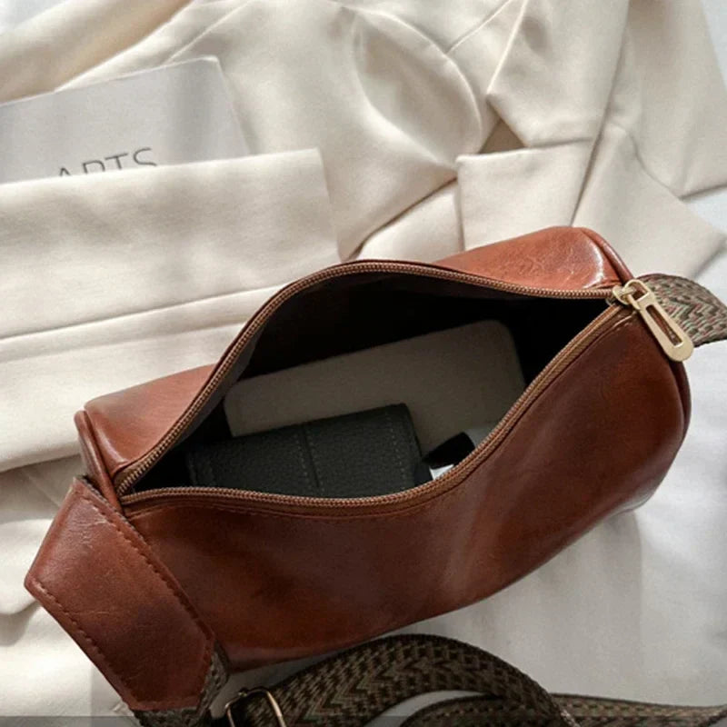Lumina Wear Florence minimalist black crossbody handbag with patterned strap, showcasing sleek design and adjustable strap length.