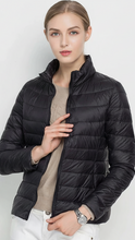 Black Lumina Wear Harriet lightweight puffer jacket with stand collar, shown in XS size on a model.