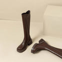 Elegant black knee-high boots by Lumina Wear featuring orthopedic support and brown fur trim, designed for comfort and style.