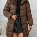 Holly cozy longline hooded puffer coat by Lumina Wear in reddish-brown, featuring a minimalist design and insulated for warmth.