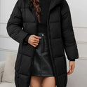 Redish-brown Lumina Wear Holly longline hooded puffer coat with minimalist design, featuring a cozy, quilted style and front pockets.