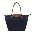 Black faux leather handbag named Isabella by Lumina Wear, featuring a spacious design and chic style.