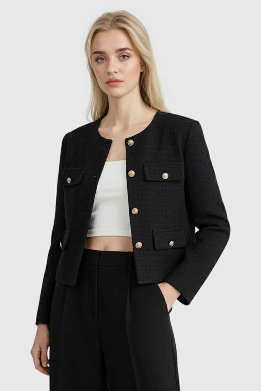 Lumina Wear Isabella black short jacket for women, stylish and versatile, shown on a model with a modern urban background.