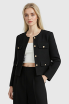 Lumina Wear Isabella black short jacket for women, stylish and versatile, shown on a model with a modern urban background.